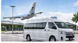 Ilustrasi minibus putih di area bandara dengan pesawat di latar belakang